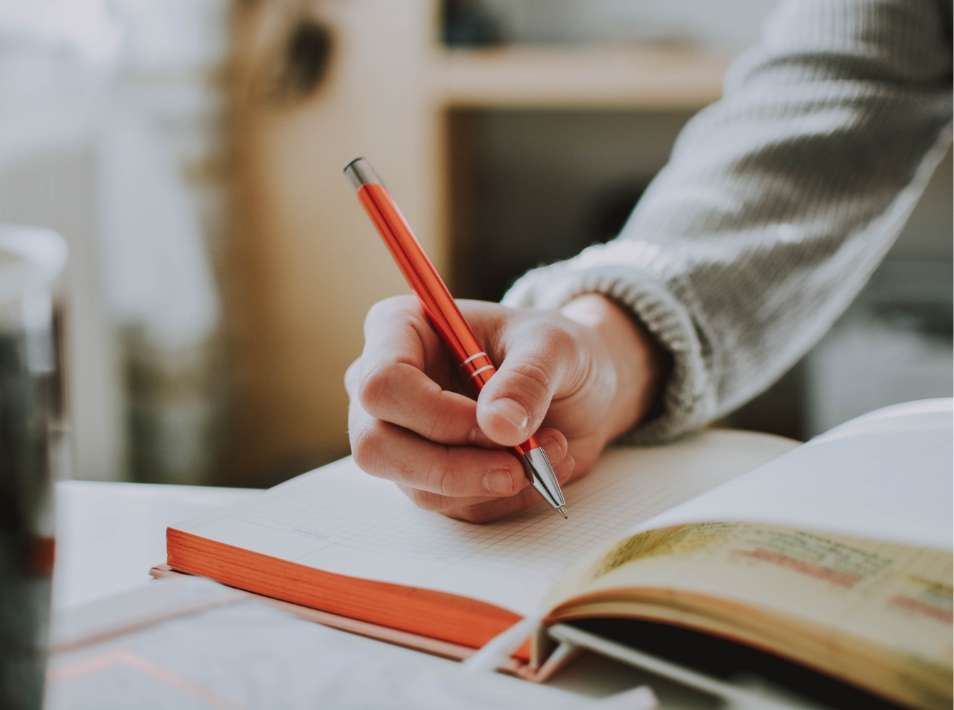 Montessori teacher writes in graph paper notebook