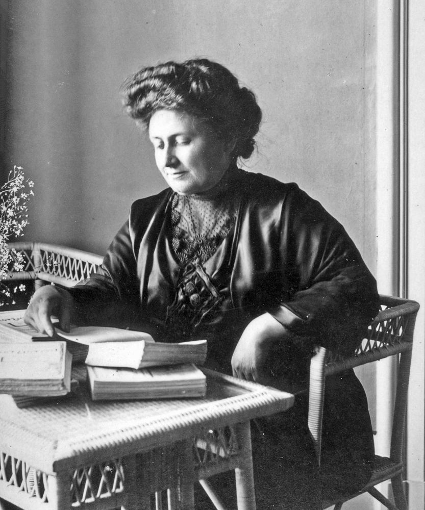 portrait of Maria Montessori reading at a desk